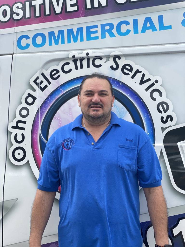 Licensed electrician Palm Beach County FL from Ochoa Electric Services standing beside company van in Port St. Lucie for panel upgrades and electrical installations.